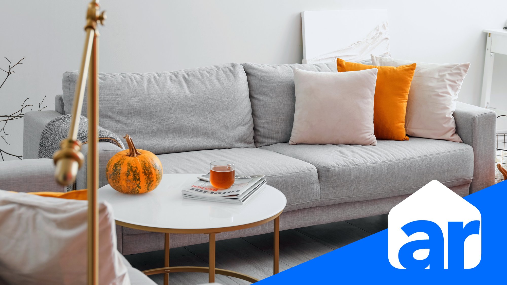 home couch with pumpkin decor and a hot drink