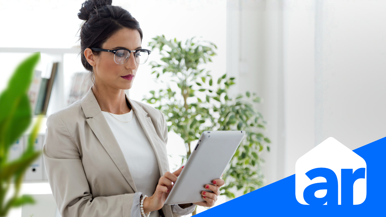 a picture of a woman holding a tablet and looking at it